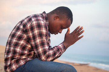 An inspiring scene of a Christian, palms clasped in prayer, gazing up into the vast blue sky,...