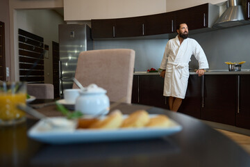 Hotel guest in a bathrobe enjoys morning in hotel room