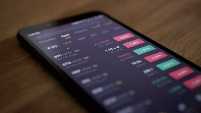 Cryptocurrency Exchange Price Data in App on a Mobile Phone Screen. Change in volume, indicators, financial indices, and quotes in a smartphone. Isolated. Growth, fall of the crypto. Online trading.
