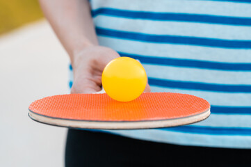 Woman holding ping pong paddle  table tennis paddle with ball. Close up.