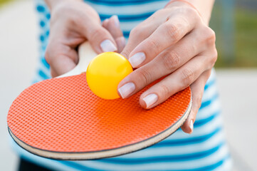 Woman holding ping pong paddle  table tennis paddle with ball. Close up.
