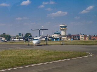 A propjet airplane in front of the airport control tower at Wilson Airport, Nairobi, Kenya