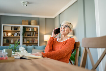 one mature senior caucasian woman use mobile phone smartphone at home