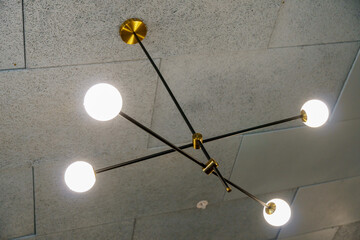 Suspended ceiling with ventilation holes and lamps. Interior design in a cafe or restaurant. Forced...