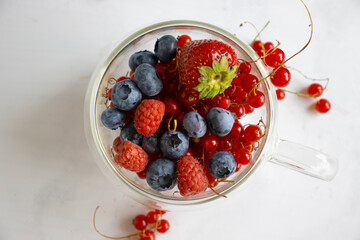 Strawberries, blueberries, currants in a cup