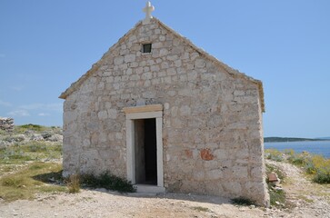 Fototapeta na wymiar Small church on the rocks of the Adriatic coast in Croatia
