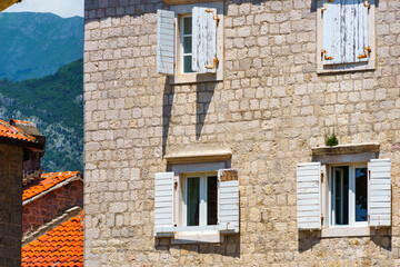 Obraz premium street view of the old town of Budva in Montenegro, medieval European architecture, city streets, windows with wooden shutters, red tiled roofs, the concept of traveling through the Balkans