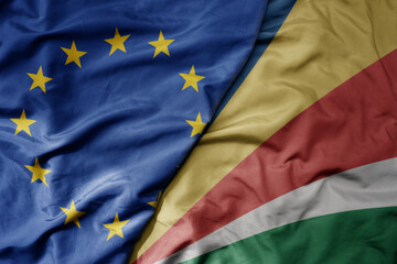 big waving realistic national colorful flag of european union and national flag of seychelles .