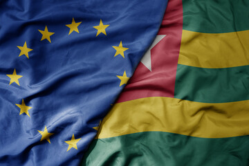 big waving realistic national colorful flag of european union and national flag of togo .
