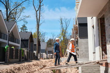 Main construction worker and male investor inspecting construction site