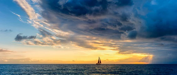Fototapeten Sunset Inspirational Approaching Storm Clouds Sailboat Hope Journey Banner Header © mexitographer