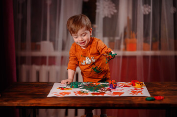 Cute little toddler boy painting with fingers at home. Creative games for kids. Stay at home...