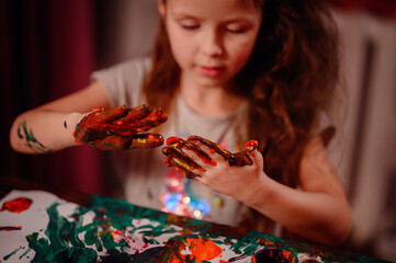Cute little girl painting with fingers at home. Creative games for kids. Stay at home entertainment