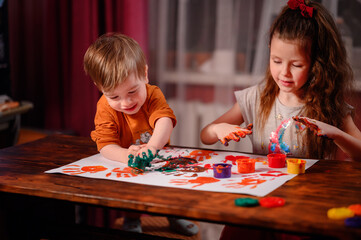 Cute little girl and boy painting with fingers at home. Creative games for kids. Stay at home...
