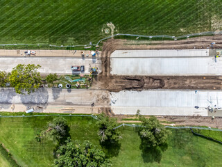 Fototapeta premium Overhead view of road construction on a partitioned road with tracked dirt. 
