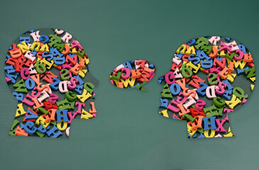 Two silhouettes of human heads with colorful letters, concept of conversation, intellectual discussion