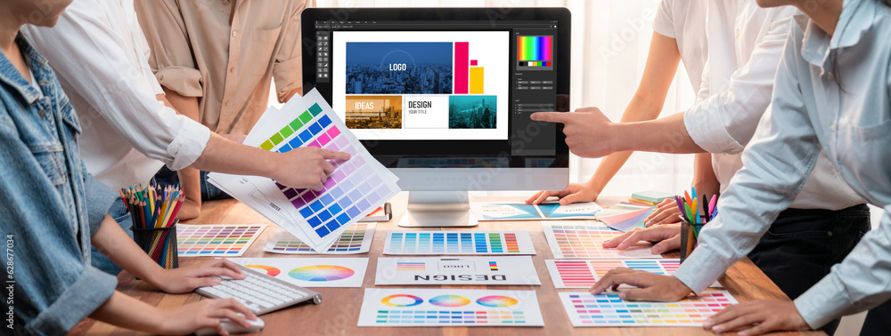 Poster graphic designer brainstorming logo and graphic art at busy artistic workshop, laptop display worksp