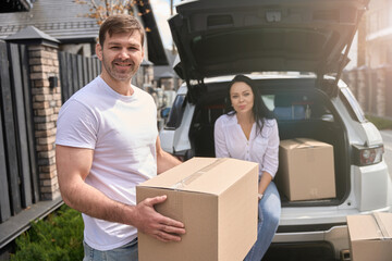 Man holding a box in front of his wife