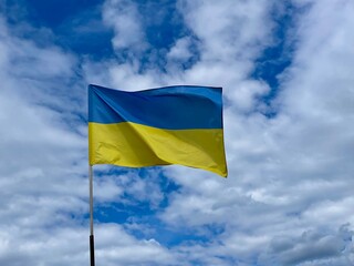 Flag of Ukraine flutters on the wind with vivid blue sky background. Ukrainian national blue and yellow flag is flying on the wind. Freedom independence and peace symbol.
