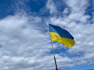 Flag of Ukraine flutters on the wind with vivid blue sky background. Ukrainian national blue and yellow flag is flying on the wind. Freedom independence and peace symbol.