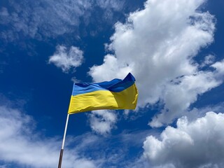 Flag of Ukraine flutters on the wind with vivid blue sky background. Ukrainian national blue and yellow flag is flying on the wind. Freedom independence and peace symbol.
