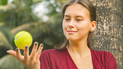 Fototapeta premium Young woman twirling a tennis ball in her hand
