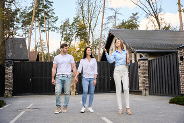 Young couple and realtor walking down the street