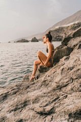 Fototapeta na wymiar Beautiful woman in bikini appreciating the landscape on a volcanic island