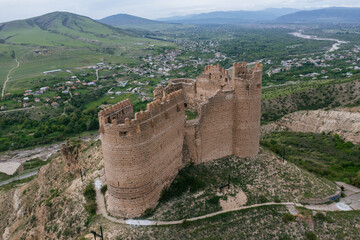 Fototapeta na wymiar Ancient old fortress. Mukhrani Ksani Castle ruin in mountains, aerial drone view