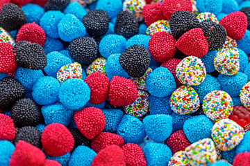 Fototapeta na wymiar abstract background of red, blue, black and white jellies in the form of raspberries. kids party
