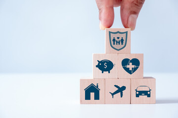 Hand giving insurance and assurance icon including family, health, real estate, car, travel and financial on wooden cube block for risk management. Insurance company client take out complete insurance