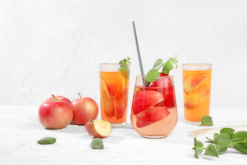 Autumn vitamin mulled wine with apple slices and mint.Apple cider, juice or fruit drink in a glass on a sunny table, Diet and weight loss concept. Apples help cleanse the body and reduce weight.
