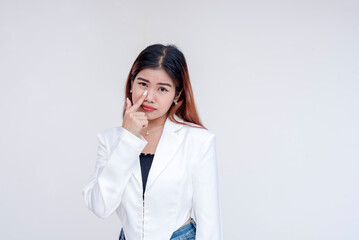 A sarcastic young woman pulling her lower eyelid with a finger to mock someone. Isolated on a white...