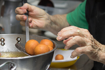 Grandmother's hands cooking traditional colombian round fritters, freshly made at home, snack and...