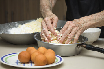 Grandmother's hands cooking traditional colombian round fritters, freshly made at home, snack and typical Colombian breakfast.