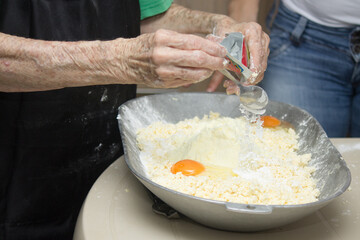 Grandmother's hands cooking traditional colombian round fritters, freshly made at home, snack and typical Colombian breakfast.