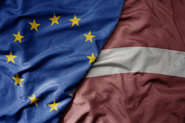 big waving realistic national colorful flag of european union and national flag of latvia . - obrazy, fototapety, plakaty