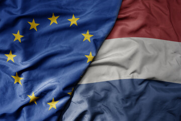 big waving realistic national colorful flag of european union and national flag of netherlands .