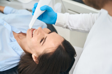 Woman client showing her teeth to dentist who check her mouth health