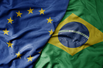 big waving realistic national colorful flag of european union and national flag of brazil .