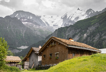 Fototapeta na wymiar Wooden huts in an Alpine village under the Bionnassay Glacier, on the French side of the Mont Blanc