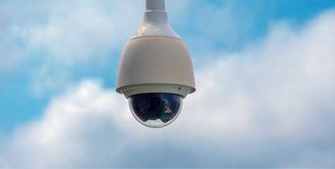 Moderne Sicherheitskamera oder Überwachungskamera in einem Außenbereich vor blauem Himmel mit...