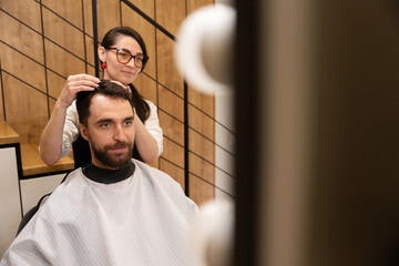 Craftswoman works with a client in a modern barbershop