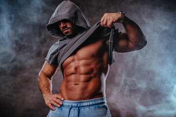 Strong man bodybuilder with hood portrait