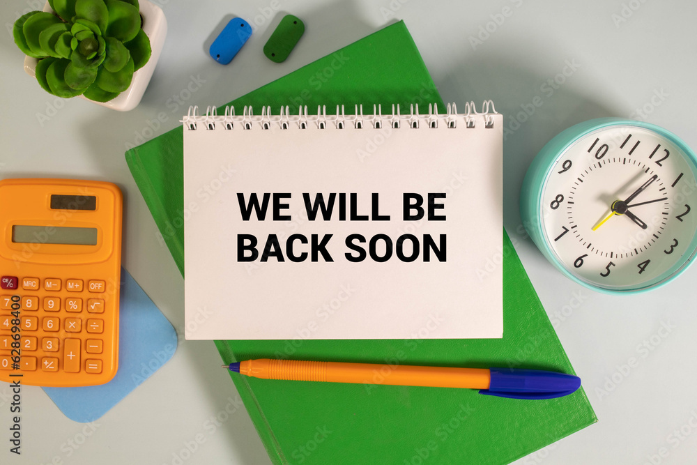 Poster we'll be back soon on sticky note on the notebook on the chart background