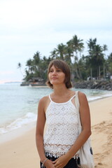 Happy young woman traveller on the tropical beach near the ocean in Sri Lanka.