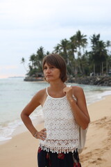 Happy young woman traveller on the tropical beach near the ocean in Sri Lanka.