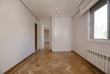 Empty room with a built-in wardrobe with white sliding doors