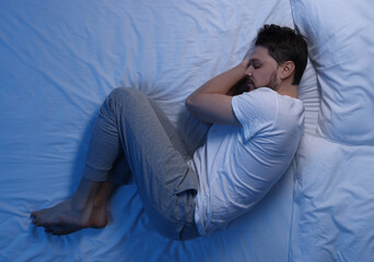 Man sleeping in bed at night, top view