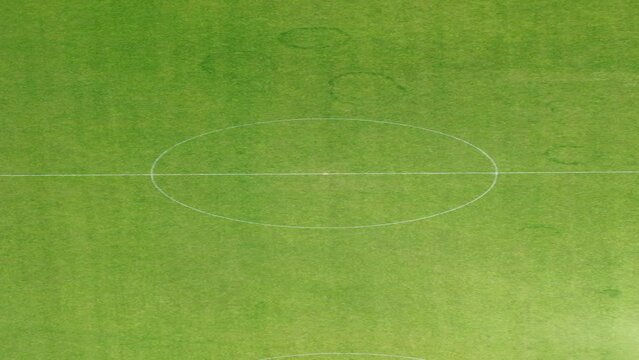 Slowly zooming out of centre of football pitch to show whole ground